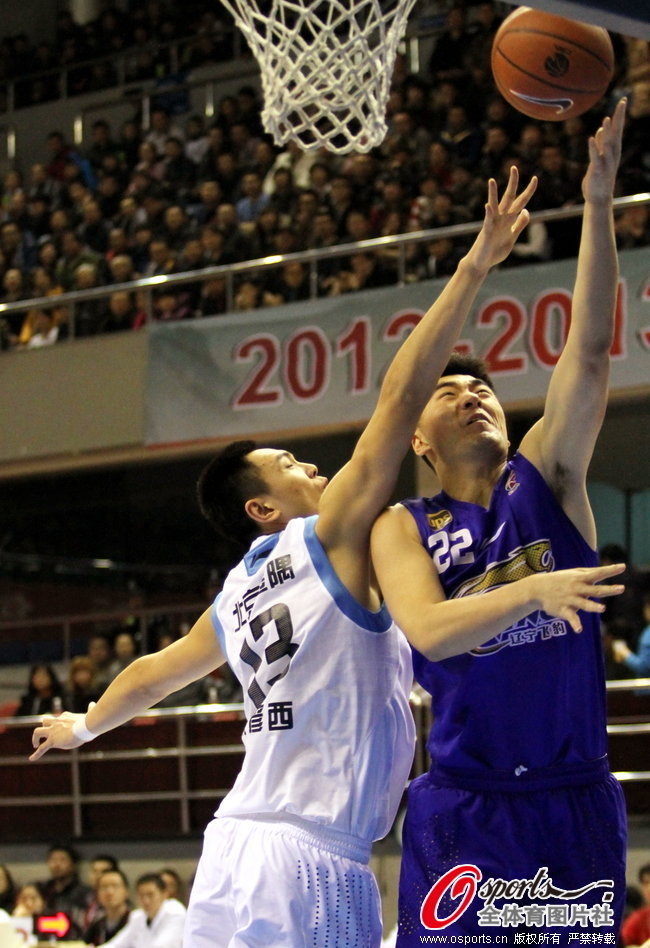 Zhu Yanxi of Beijing tries to block Li Xiaoxu's shot during a CBA game between Beijing and Liaoning on Jan. 8, 2013.