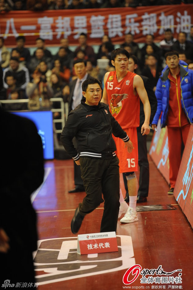 A Qingdao team staff, center, kicks off the name placard for technique officials in strong protest of the referees' controversial decisions during their CBA League game against Bayi Fubang in Ningbo, Zhejiang province, Jan 9, 2012. [Photo/CFP] 