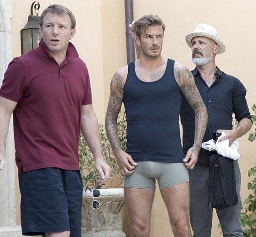 David Beckham and Guy Ritchie during a pause in filming. The soccer superstar is stripping down to just his underwear in a new campaign for HM's David Beckham Bodywear collection. [Photo:Sina.com]