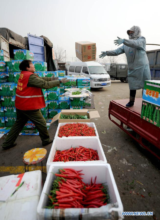 Workers unload capsicums from a truck at the Xinfadi farm products whole sale market in Beijing, China, Jan. 10, 2013. Farm produce prices in China climbed for the tenth straight week during the seven days ending Jan. 6, as cold weather has cut supplies, figures from the Ministry of Commerce showed on Jan. 9. The wholesale price of 18 types of vegetables monitored across 36 major cities gained 7.1 percent from the previous week, the ministry said.