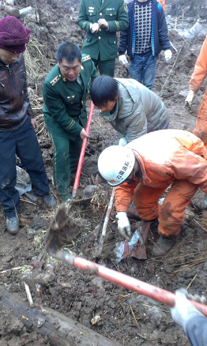  A rescuer works at the landslide site at Gaopo Village of Zhenxiong County, southwest China&apos;s Yunnan Province, Jan. 11, 2013. More than 10 residential houses with over 40 people were buried after a landslide happened at the village early Friday morning, according to local officials. 