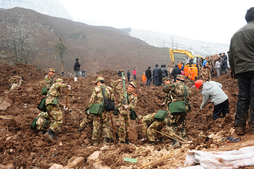 Rescuers work at the landslide site at Gaopo Village of Zhenxiong County, southwest China's Yunnan Province, Jan. 11, 2013. More than 10 residential houses with over 40 people were buried after a landslide happened at the village early Friday morning, according to local officials.