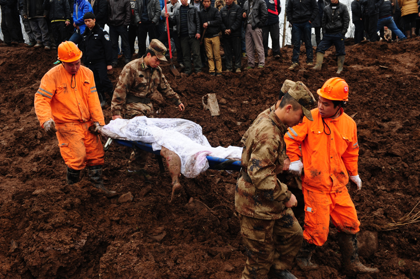 Rescuers work at the landslide site at Gaopo Village of Zhenxiong County, southwest China's Yunnan Province, Jan. 11, 2013. More than 10 residential houses with over 40 people were buried after a landslide happened at the village early Friday morning, according to local officials.