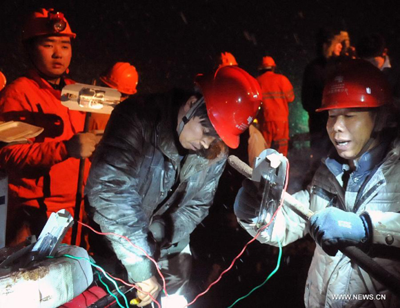 Electricians work to provide temporary power supply at the landslide site at Gaopo Village in Zhenxiong County, southwest China's Yunnan Province, Jan. 11, 2013.