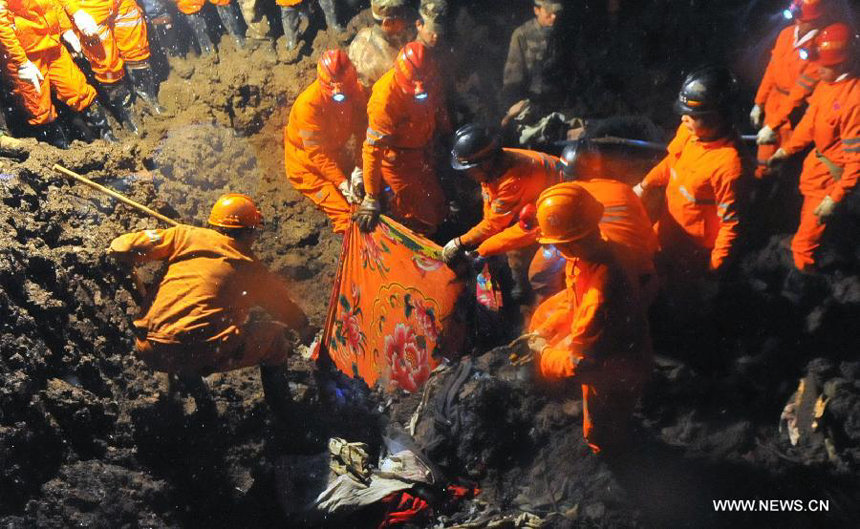 Rescuers find a victim&apos;s body at the mud-inundated debris after a landslide hit Gaopo Village in Zhenxiong County, southwest China&apos;s Yunnan Province, Jan. 11, 2013. 