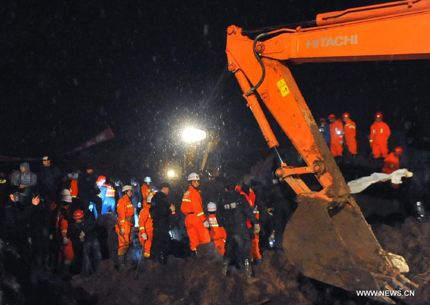 Rescuers and an excavator work at the mud-inundated debris after a landslide hit Gaopo Village in Zhenxiong County, southwest China&apos;s Yunnan Province, Jan. 11, 2013.