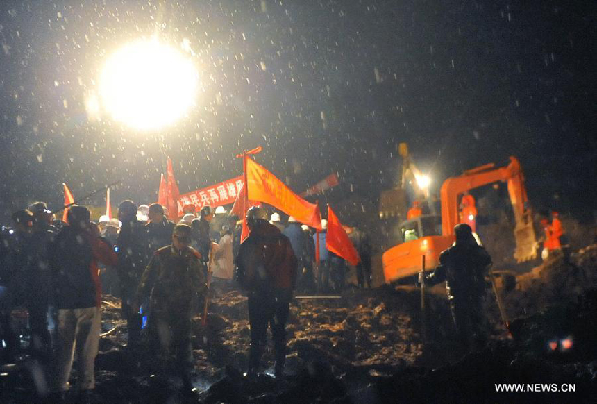 Rescuers work at the mud-inundated debris after a landslide hit Gaopo Village in Zhenxiong County, southwest China&apos;s Yunnan Province, Jan. 11, 2013.