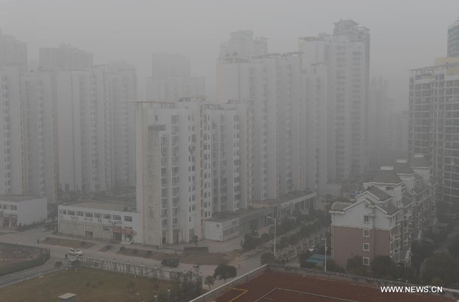 Fog-shrouded buildings are seen in the Honggutan New District of Nanchang City, capital of east China&apos;s Jiangxi Province, Jan. 12, 2013. A fog hit many parts of Jiangxi on Saturday. 