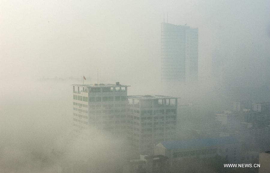 Buildings are seen amid dense fog in Wuhan City, capital of central China&apos;s Hubei Province, Jan. 12, 2013.