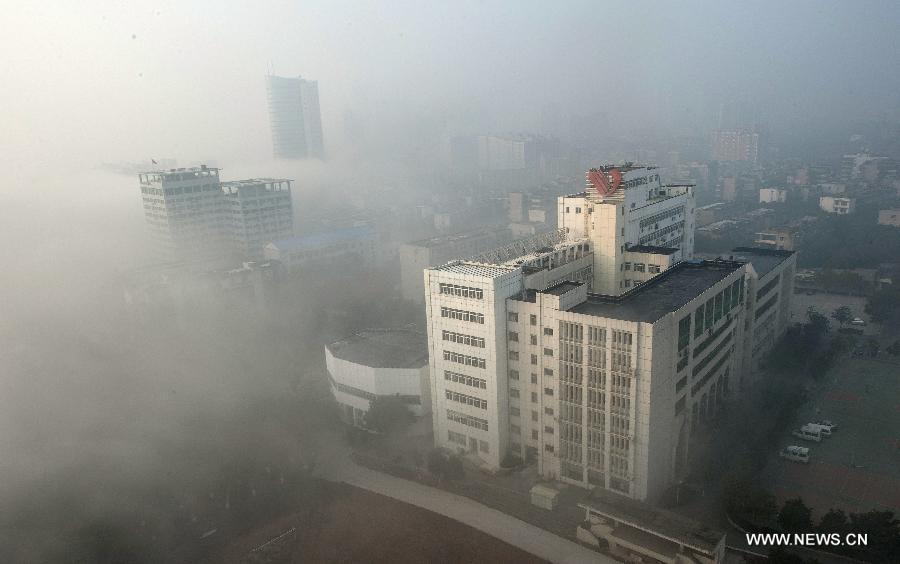 Buildings are seen amid dense fog in Wuhan City, capital of central China&apos;s Hubei Province, Jan. 12, 2013. 