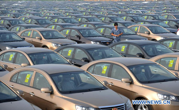 A worker walks among new sedans at Geely Auto Ningbo factory in Ningbo, east China's Zhejiang Province, July 19, 2012. China remained the world's largest producer and market for automobiles for the fourth consecutive year in 2012, according to data released on Jan. 11, 2013 by China Association of Automobile Manufacturers (CAAM).