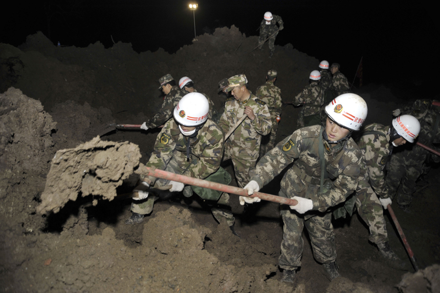 Rescuers work at the mud-inundated debris after a landslide hit Gaopo Village in Zhenxiong County, southwest China&apos;s Yunnan Province, Jan. 12, 2013. 