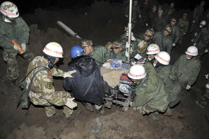 Rescuers work at the mud-inundated debris after a landslide hit Gaopo Village in Zhenxiong County, southwest China&apos;s Yunnan Province, Jan. 12, 2013. 