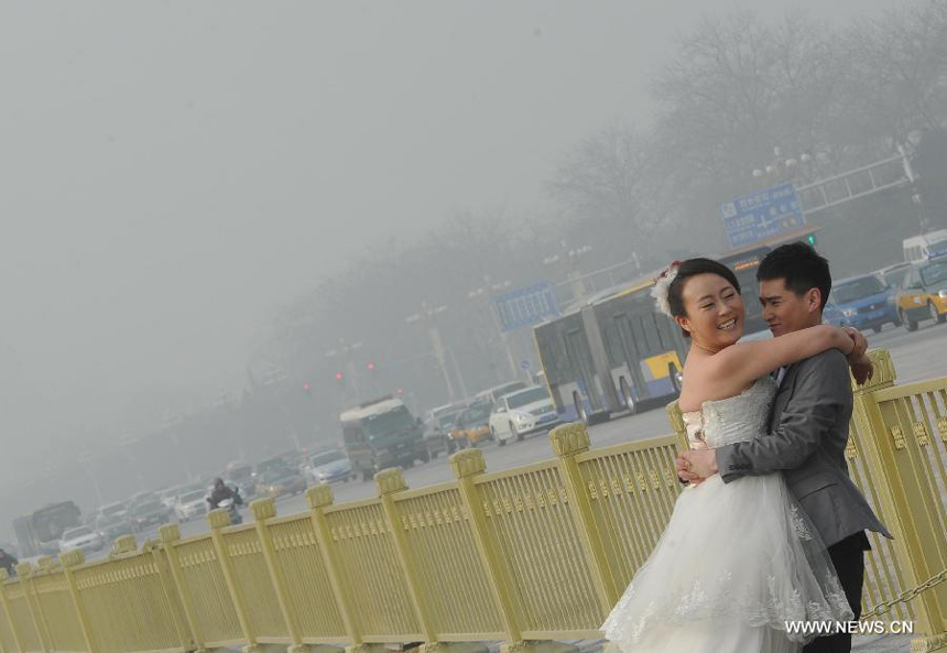 A couple pose for wedding photos at the Tian&apos;anmen Square in Beijing, capital of China, Jan. 11, 2013. The PM 2.5 (particles less than 2.5 microns) data in Beijing hit 240 to 446 on Friday, which means the 6 rating heavily polluted air quality.