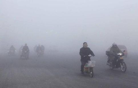 Citizens ride in the fog on a street in Ganyu County of Lianyungang City, east China's Jiangsu Province, Jan. 13, 2013. Dense fog on Sunday hit China's east and central regions from the northeast to the south. [Xinhua]