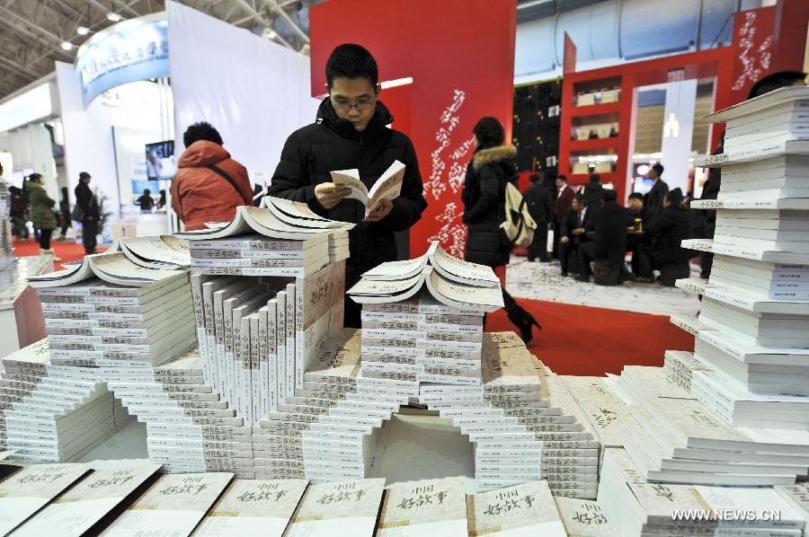 Citizens watch books during the 2013 Beijing Book Fair at the China International Exhibition Centre in Beijing, capital of China, Jan. 11, 2013. 