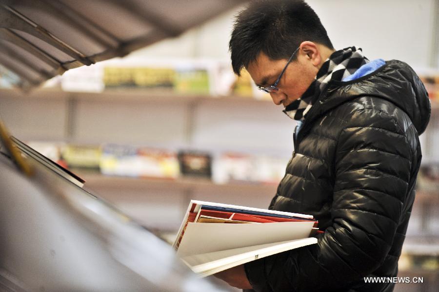 A citizen views books during the 2013 Beijing Book Fair at the China International Exhibition Centre in Beijing, capital of China, Jan. 11, 2013. 