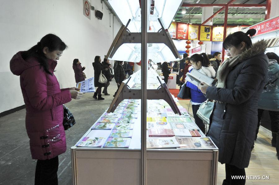 Citizens watch books during the 2013 Beijing Book Fair at the China International Exhibition Centre in Beijing, capital of China, Jan. 11, 2013. 
