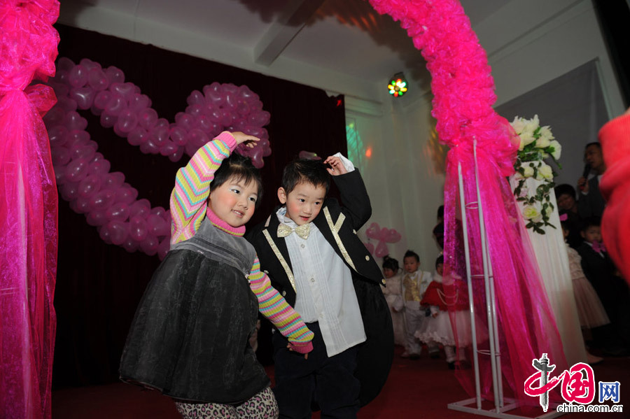 2013年1月11日，河南郑州，图为众人的祝福声中，他们牵手走过彩虹门，在彩虹门前来一个“定格”，做一个亲密动作，拥抱接吻都可以。[张翼飞/CFP]
