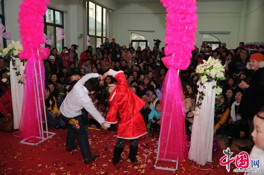 2013年1月11日，河南郑州，图为众人的祝福声中，他们牵手走过彩虹门，在彩虹门前来一个“定格”，做一个亲密动作，拥抱接吻都可以。[张翼飞/CFP]