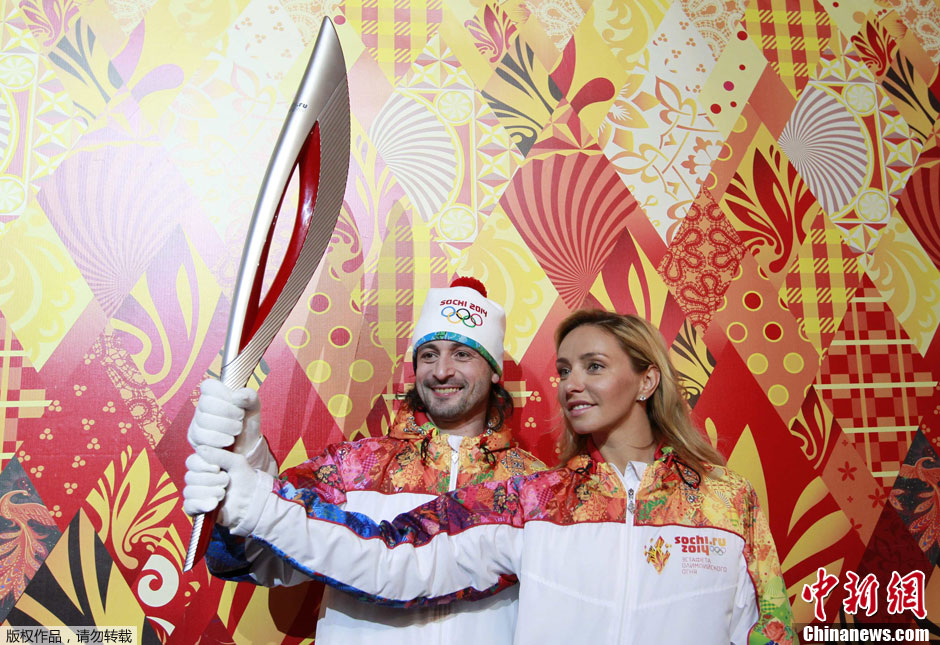 Russian ice dancers Tatyana Navka (R) and Ilya Averbukh hold the Olympic torch for the Sochi 2014 Winter Olympics during a presentation ceremony in Moscow January 14, 2013.