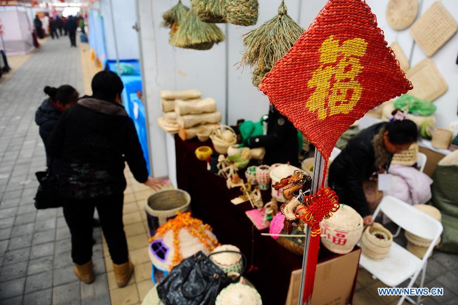 Visitors select handicraft artworks during the 4th Jilin Agricultural Expo for Winter in Changchun, capital of northeast China's Jilin Province, Jan. 16, 2013. 