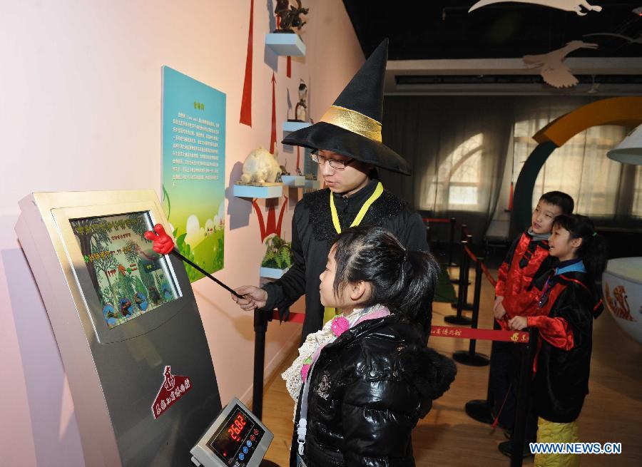 A working staff helps a girl measure her weight at the science experience hall for youths in the Heilongjiang Museum in Harbin, capital of northeast China's Heilongjiang Province, Jan. 15, 2013. 