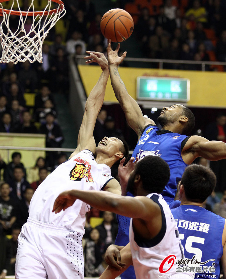 Yi Jianlian of Guangdong and Marcus Haislip of Dongguan vie for the rebound during a CBA game on Jan.15, 2013. 