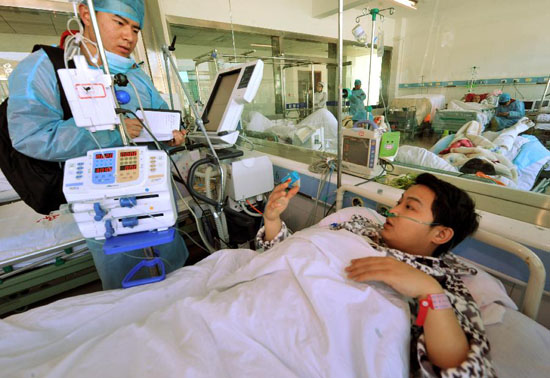 Sun Qisong (R), a survivor of a coal mine accident, receives interview in a hospital in southwest China's Guizhou Province, Jan. 19, 2013. The accident which occurred on Friday afternoon at the Jinjia Coal Mine under the Panjiang Investment Holding Group has left two people dead and 11 others trapped. Eighteen people were working underground at the time of the accident. Three of the five miners who have been lifted out of the mine were injured. [Xinhua/Yang Ying] 