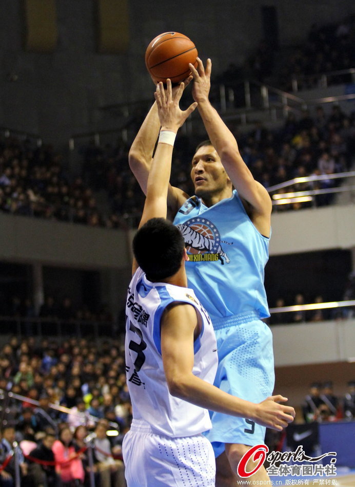  Batter of Xinjiang shoots in front of Zhu Yanxi during a CBA game between Beijing and Xinjiang on Jan.20, 2013.