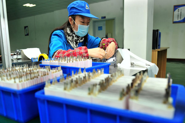 A worker assembles environmentally friendly lithium batteries at an industrial park in Yichang, Hubei province. A survey found that China retains fi rst place in terms of competitiveness in manufacturing, followed by Germany and the United States. [Photo/China Daily]