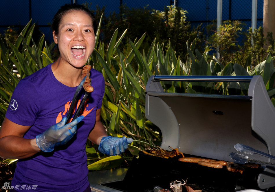 Li Na prepares to eat a sausage she cooked on a barbecue at the Australian Open in Melbourne on Jan.22, 2013.