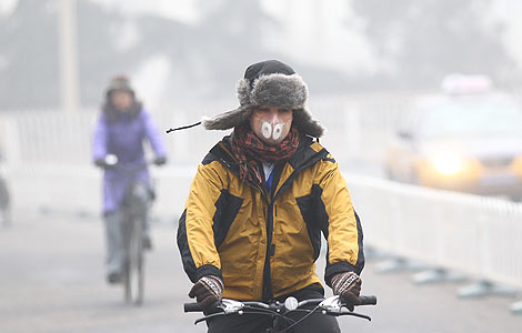A man wearing a mask rides a bicycle on a hazy day in Beijing, Jan 23, 2013. [Photo by Zou Hong/Asianewsphoto] 
