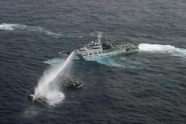 An aerial view shows a Japan Coast Guard patrol ship (R) spraying water at a fishing boat (L) that is carrying Taiwan's activists on board about 32 km (20 miles) west-southwest of one of the Diaoyu Islands in the East China Sea, in this picture released by the Japan Coast Guard's 11th Regional Coast Guard headquarters January 24, 2013.[Photo/Agencies]
