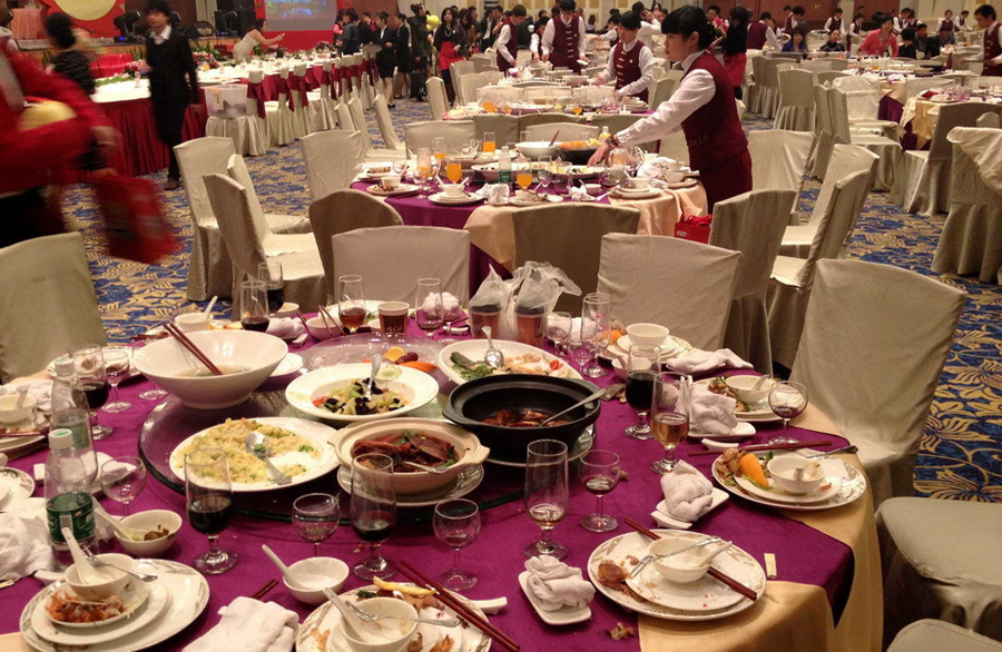 Hotel staff clears tables after a get-together held by a state-owned enterprise in Guangzhou, Guangdong Province, on Jan. 20, 2013. More than 70 tables were served, each costing 3,900 yuan (US$627).[Xinhua] 