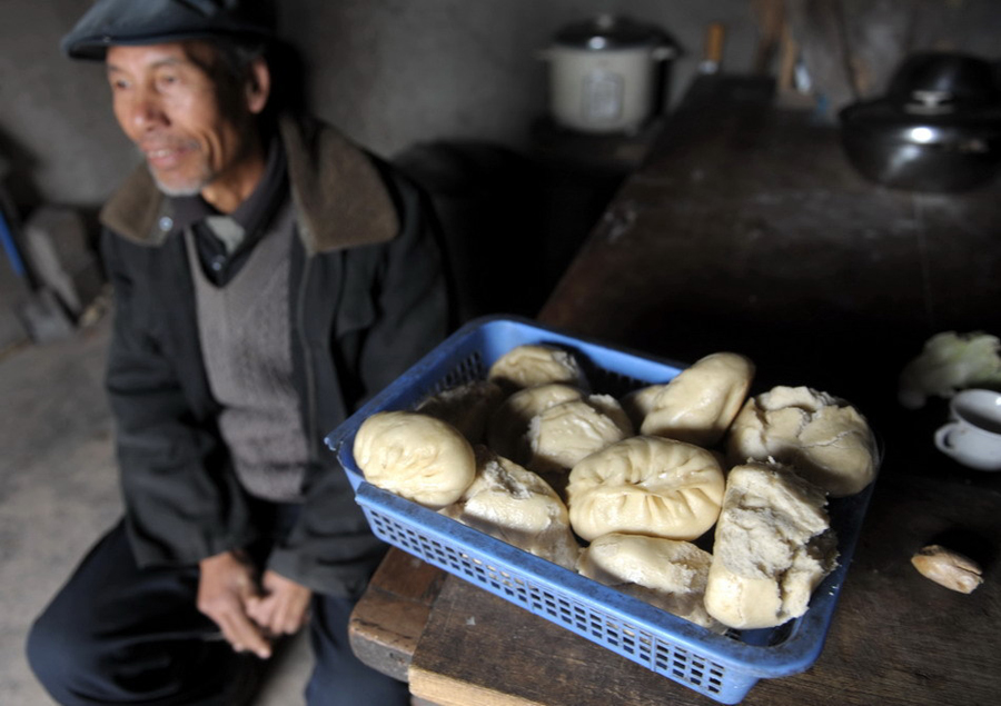 A container of steamed buns constitutes a week’s worth of food for Wang Yizhong. 64-year-old Wang is a poor villager from Longnan, Gansu Province. “I haven’t eaten in a restaurant for many years. And every year I can only afford to eat 10 meals with meat,” Wang said. [Xinhua]