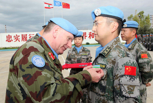Chinese members of a UN peacekeeping force receive service medals from a UN official at a military camp in Lebanon on December 5, 2012 [Photo/Liu Shun] 