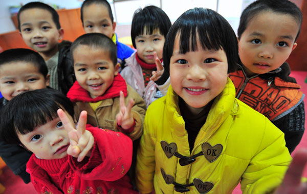 Children pose for a photo at a orphanage in Jinjiang, Fujian province, Jan 22. The 23 children were abducted by kidnappers to sell until they rescued by police in 2005, but they have been unable to trace their parents. [Photo/Xinhua]