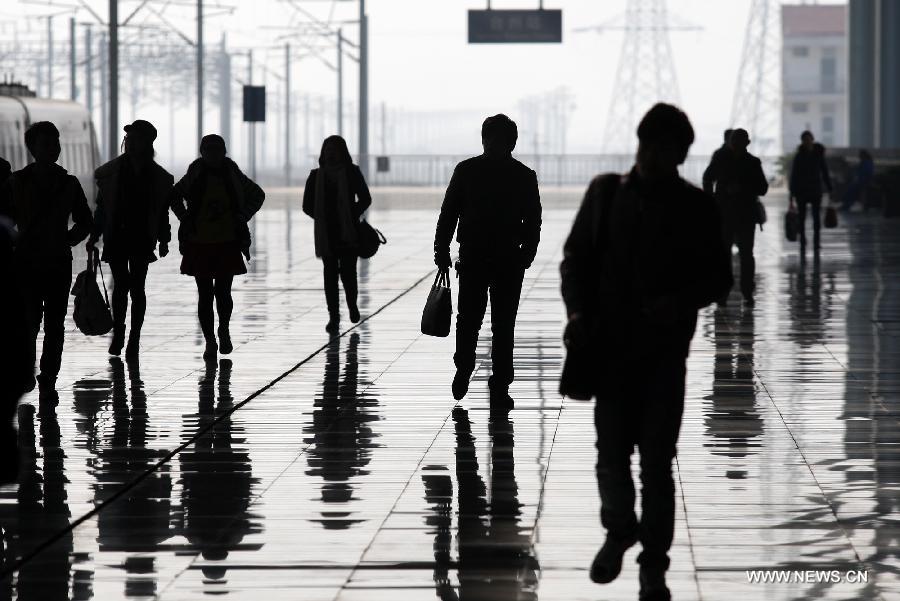 Passengers prepare to board a train at Taizhou Railway Station in Taizhou City, east China's Zhejiang Province, Jan. 26, 2013