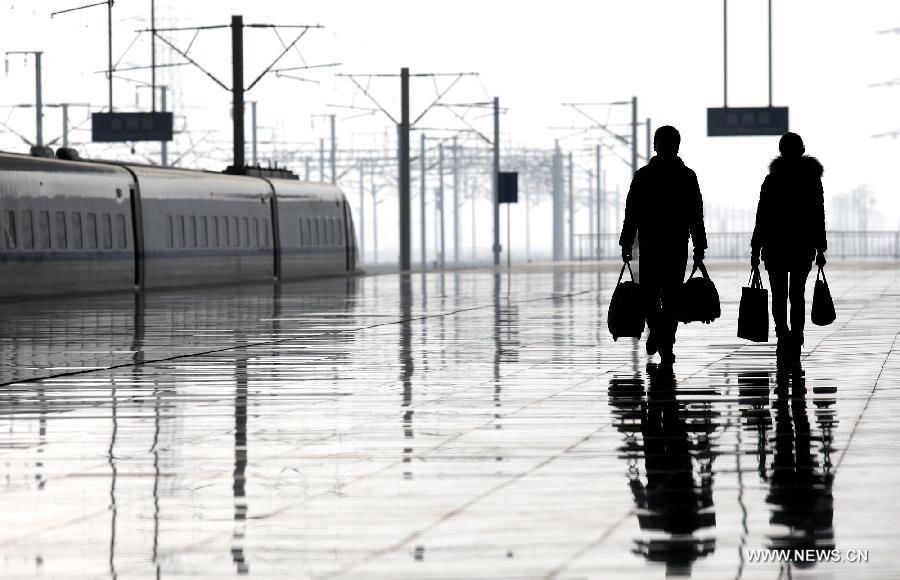 Passengers prepare to board a train at Taizhou Railway Station in Taizhou City, east China's Zhejiang Province, Jan. 26, 2013