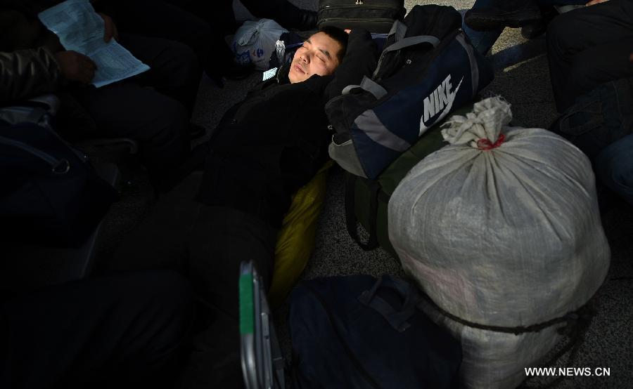 A passenger sleeps as he waits to board a train at Yinchuan Railway Station, in Yinchuan, capital of northwest China's Ningxia Hui Autonomous Region, Jan. 26, 2013