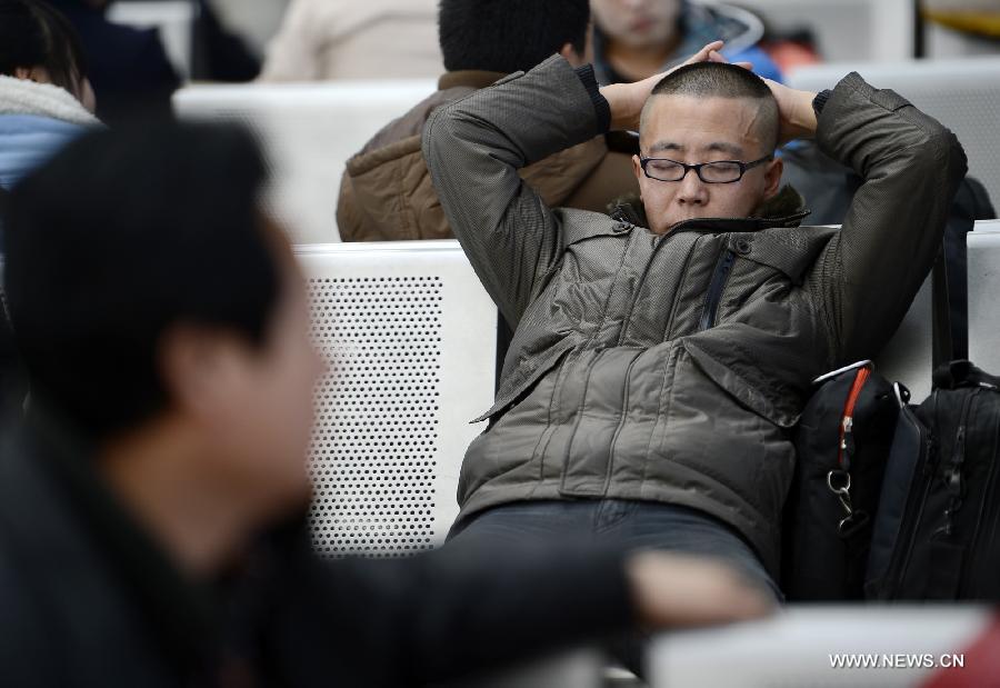 A passenger sleeps as he waits to board a train at Yinchuan Railway Station, in Yinchuan, capital of northwest China's Ningxia Hui Autonomous Region, Jan. 26, 2013