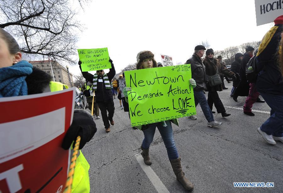 People hold signs against gun violence during a march in Washington D.C., capital of the United States, Jan. 26, 2013. Thousands of people, including family members of victims and survivors of shootings at Virginia Tech University, Sandy Hook elementary school and others, took part in a march for stricter gun control laws here on Saturday. [Zhang Jun/Xinhua]