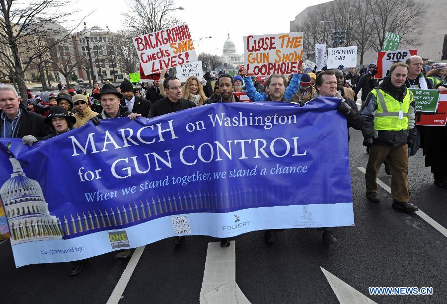 People hold signs against gun violence during a march in Washington D.C., capital of the United States, Jan. 26, 2013. Thousands of people, including family members of victims and survivors of shootings at Virginia Tech University, Sandy Hook elementary school and others, took part in a march for stricter gun control laws here on Saturday. [Zhang Jun/Xinhua]