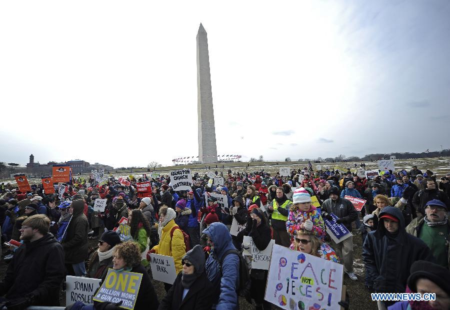 People hold signs against gun violence during a march in Washington D.C., capital of the United States, Jan. 26, 2013. Thousands of people, including family members of victims and survivors of shootings at Virginia Tech University, Sandy Hook elementary school and others, took part in a march for stricter gun control laws here on Saturday. [Zhang Jun/Xinhua]