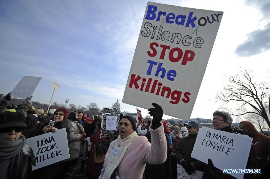 People hold signs against gun violence in front of the Capitol Hill during a march in Washington D.C., capital of the United States, Jan. 26, 2013. Thousands of people, including family members of victims and survivors of shootings at Virginia Tech University, Sandy Hook elementary school and others, took part in a march for stricter gun control laws here on Saturday. [Zhang Jun/Xinhua]