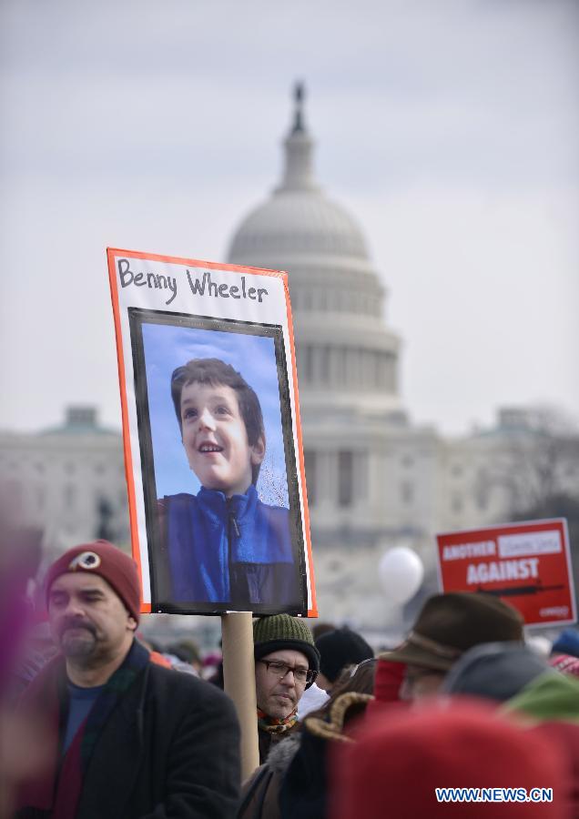 People hold the picture of Benny Wheeler, a victim of the Sandy Hook school shooting, in front of the Capitol Hill during a march in Washington D.C., capital of the United States, Jan. 26, 2013. Thousands of people, including family members of victims and survivors of shootings at Virginia Tech University, Sandy Hook elementary school and others, took part in a march for stricter gun control laws here on Saturday. [Zhang Jun/Xinhua]