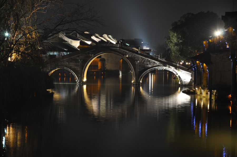 With a history of 1,200-years, Wuzhen is about one hour's drive from Hangzhou, the capital of Zhejiang province. The small town is famous for the ancient buildings and old town layout, where bridges of all sizes cross the streams winding through the town.[Photo by Yuan Fang/China.org.cn]