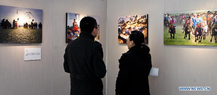 Visitors watch photography works during Inner Mongolia Ecology Photographs Exhibition in Beijing, capital of China, Jan. 28, 2013. (Xinhua/Zheng Huansong) 