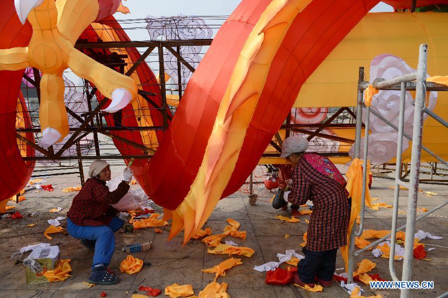 Women work on a lantern in the shape of Chinese dragon on the street in Nanchang, capital of east China's Jiangxi Province, Jan. 28, 2013. Lanterns designed in Zigong of southwest China's Sichuan Province will meet with the residents here during the upcoming Spring Festival holidays. (Xinhua/Zhou Mi) 